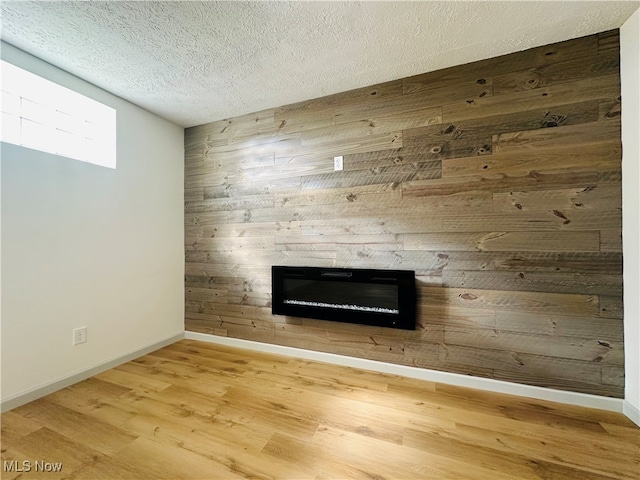 interior details with a textured ceiling, wooden walls, and hardwood / wood-style flooring