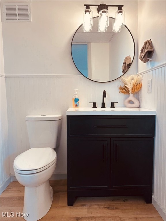 bathroom featuring wood-type flooring, vanity, and toilet