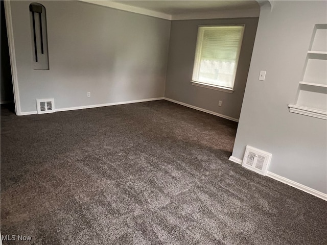 spare room featuring dark carpet