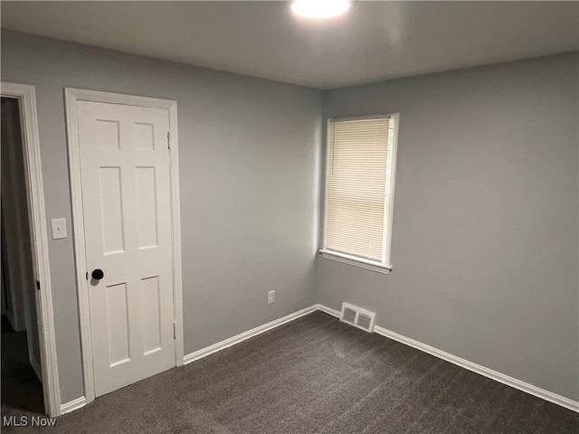 empty room with dark colored carpet