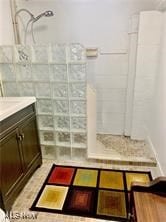 bathroom featuring vanity and a tile shower