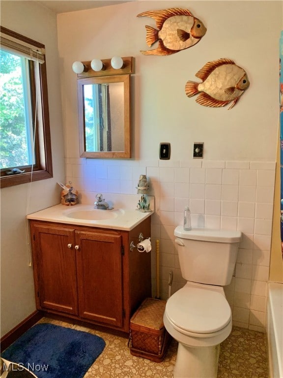 full bathroom with vanity, tile walls, shower with separate bathtub, and toilet