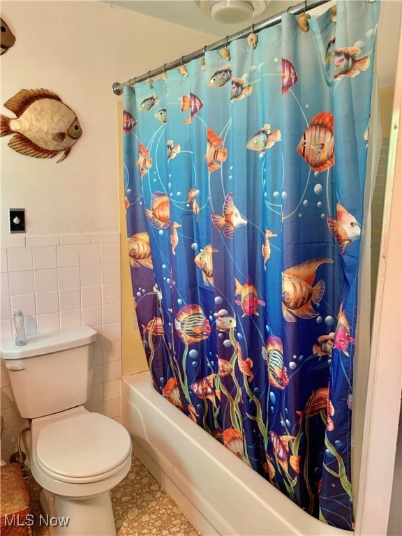 bathroom featuring tile walls, shower / tub combo, toilet, and tile patterned flooring