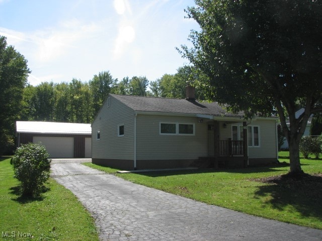 view of front of property with an outbuilding, a garage, and a front yard