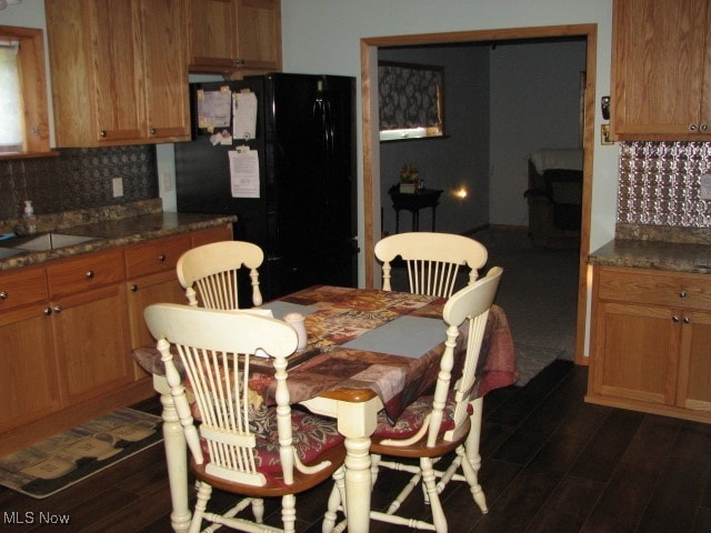 dining area with sink and dark wood-type flooring