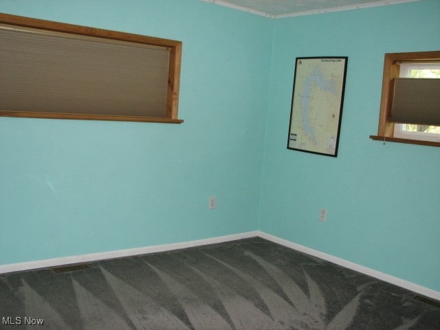 carpeted spare room featuring crown molding