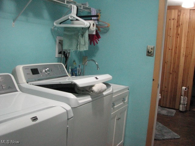 clothes washing area with cabinets and washing machine and dryer