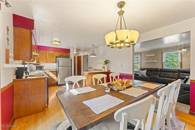 dining space featuring light hardwood / wood-style floors and an inviting chandelier