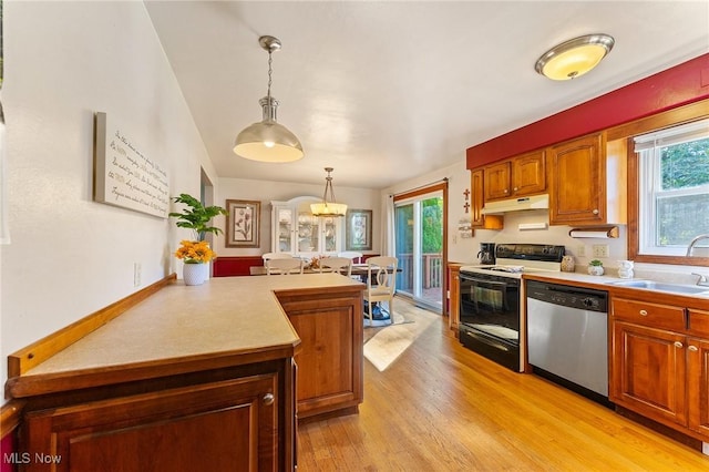 kitchen with a wealth of natural light, range with electric cooktop, dishwasher, hanging light fixtures, and sink