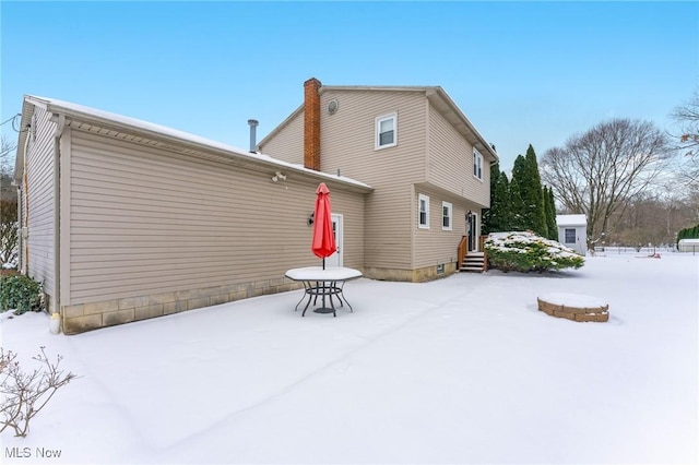 view of snow covered rear of property