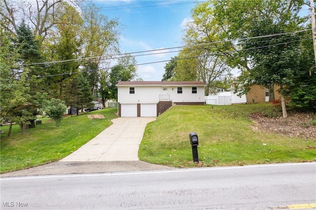 raised ranch featuring a front yard and a garage