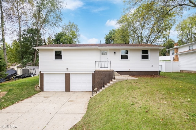 rear view of house with a lawn and a garage