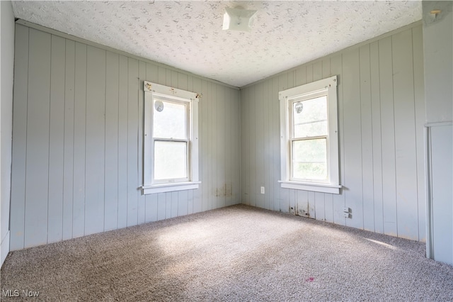 carpeted empty room featuring a textured ceiling