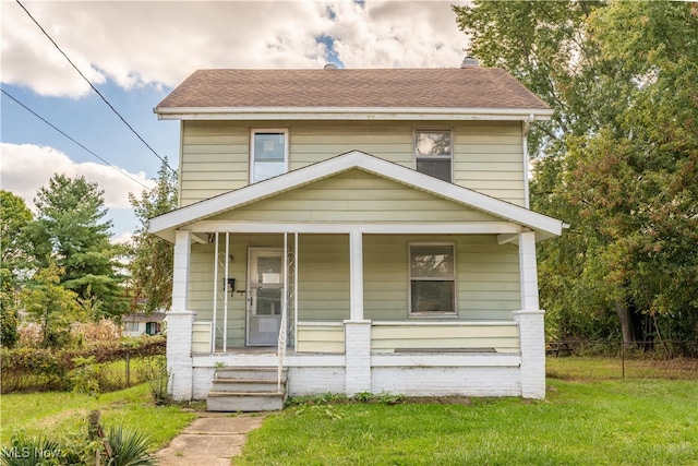 view of front of home with a porch and a front yard