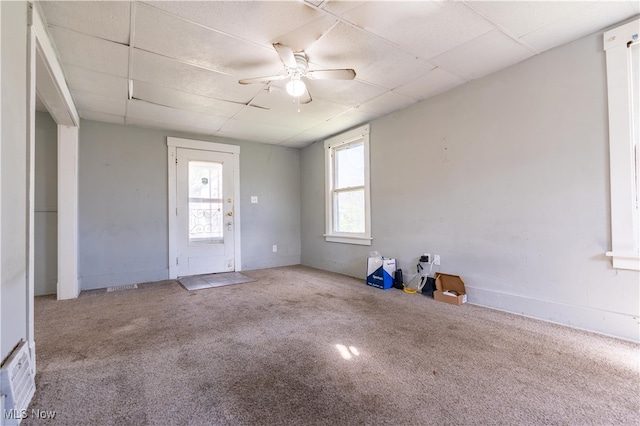 carpeted spare room featuring ceiling fan and a paneled ceiling