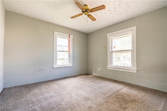 carpeted spare room featuring ceiling fan and a textured ceiling