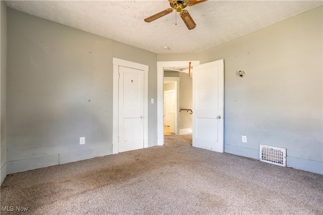 unfurnished bedroom featuring ceiling fan, carpet, and a textured ceiling