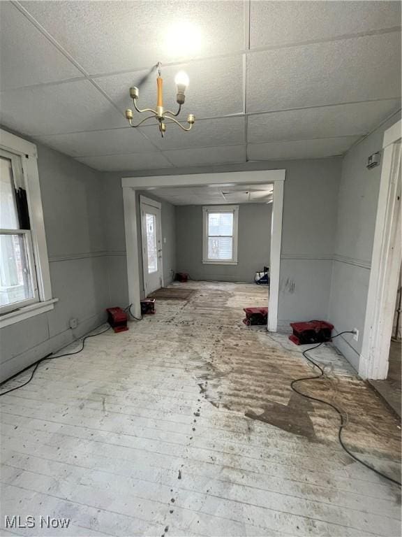 spare room with wood-type flooring, a paneled ceiling, and a chandelier