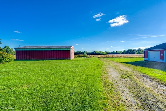 view of yard featuring a rural view and an outbuilding