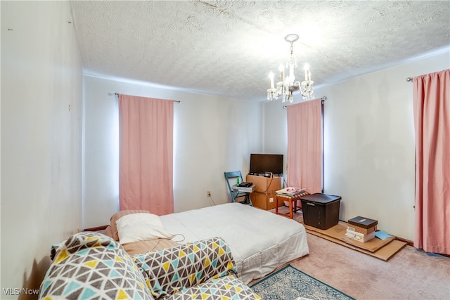 carpeted bedroom with a textured ceiling and a notable chandelier