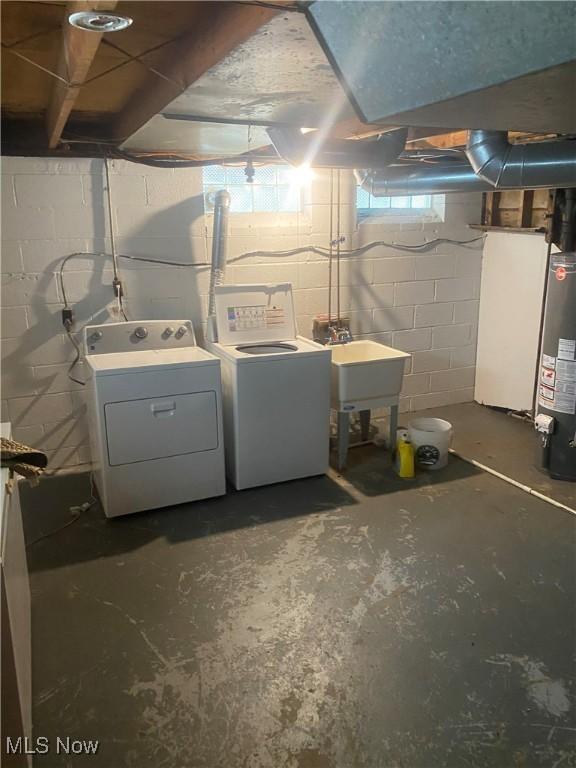 basement with separate washer and dryer, a sink, and water heater