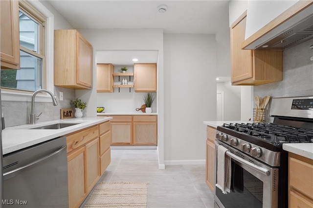 kitchen with wall chimney exhaust hood, sink, light tile patterned floors, light brown cabinetry, and appliances with stainless steel finishes