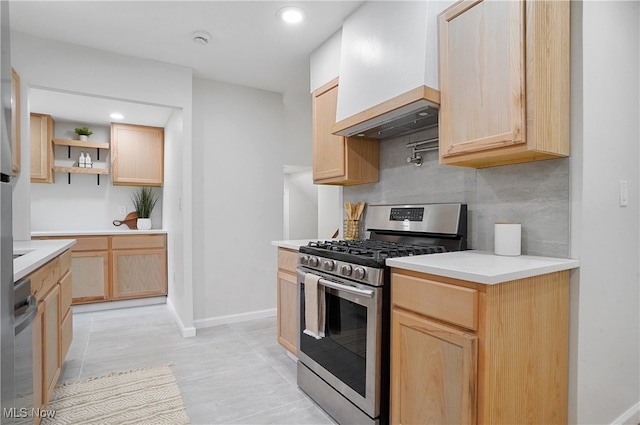 kitchen with custom range hood, light brown cabinetry, and stainless steel gas range