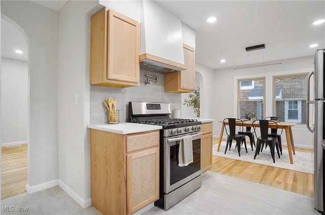 kitchen with custom exhaust hood, light brown cabinets, stainless steel appliances, and light wood-type flooring