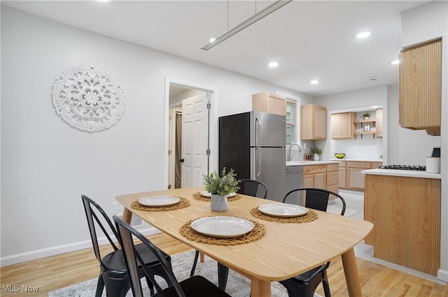 dining room with sink and light hardwood / wood-style flooring