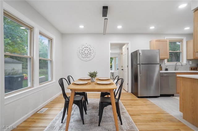 dining room featuring sink and light hardwood / wood-style flooring