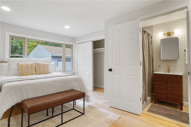 bedroom featuring sink, a closet, and light hardwood / wood-style floors