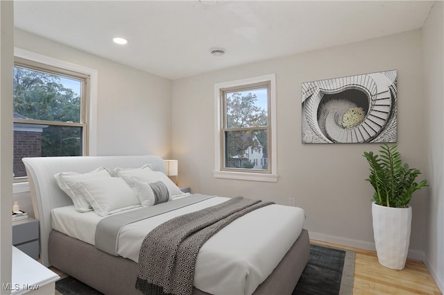 bedroom with light hardwood / wood-style flooring and multiple windows