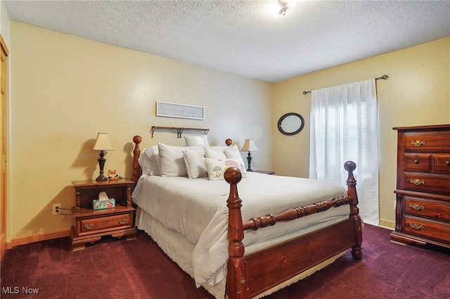 bedroom featuring dark carpet and a textured ceiling