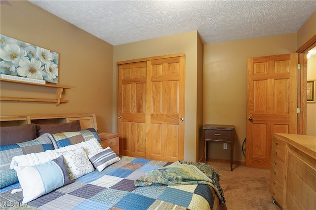 carpeted bedroom with a textured ceiling and a closet