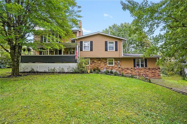 back of property with a sunroom and a yard