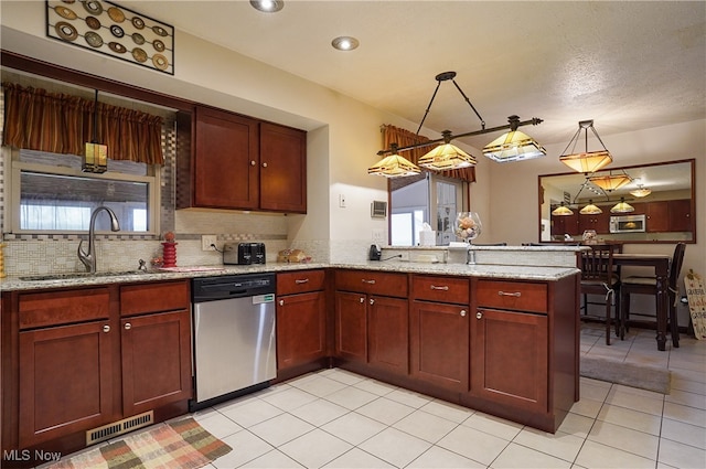 kitchen featuring hanging light fixtures, sink, kitchen peninsula, dishwasher, and light stone countertops