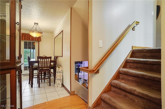 staircase featuring hardwood / wood-style flooring and a textured ceiling