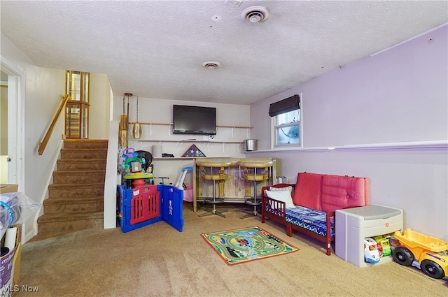 recreation room featuring carpet floors, a textured ceiling, and bar