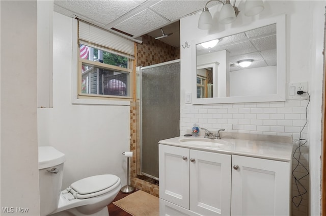 bathroom with backsplash, a shower with door, hardwood / wood-style floors, vanity, and toilet