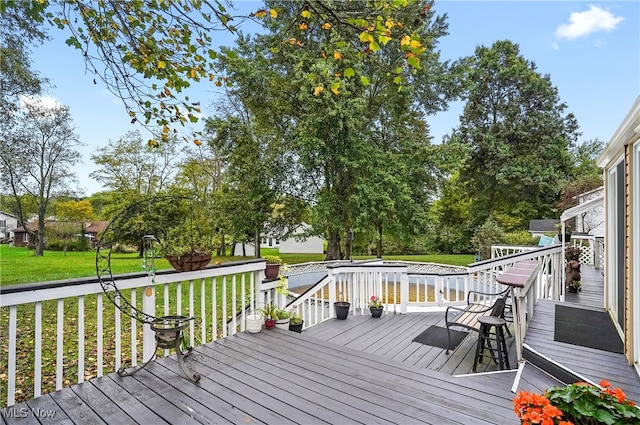 wooden deck featuring a lawn