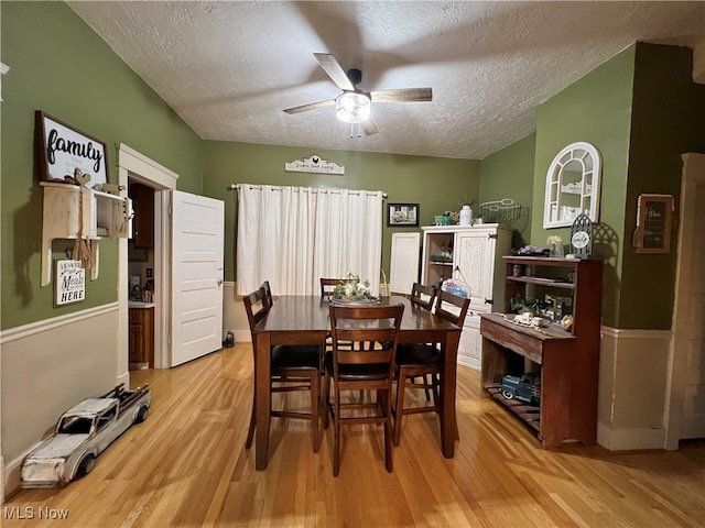 dining room with light wood-type flooring, a textured ceiling, and ceiling fan