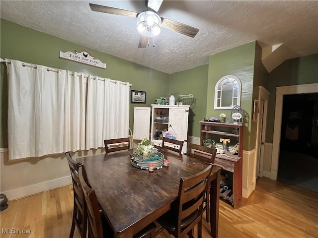 dining space featuring light wood-type flooring, a textured ceiling, and ceiling fan