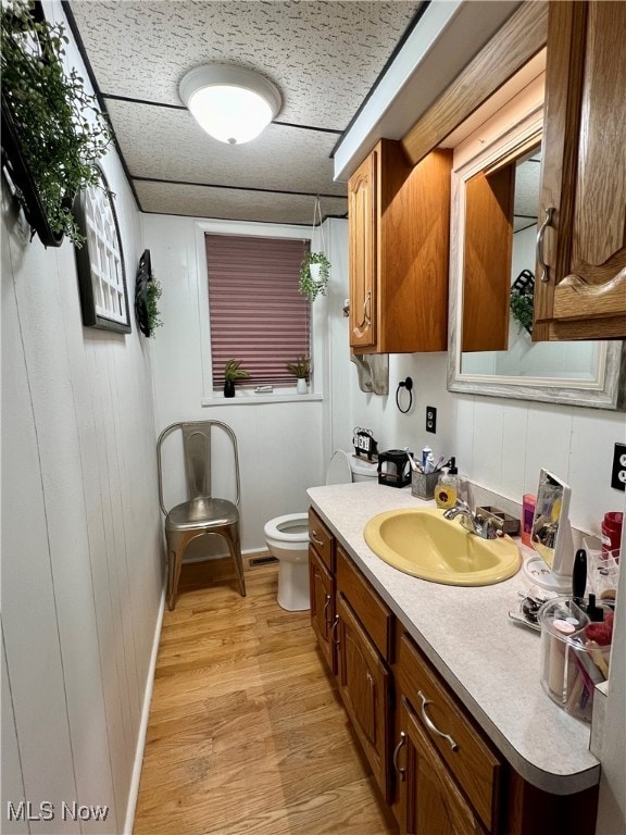 bathroom featuring hardwood / wood-style flooring, vanity, and toilet