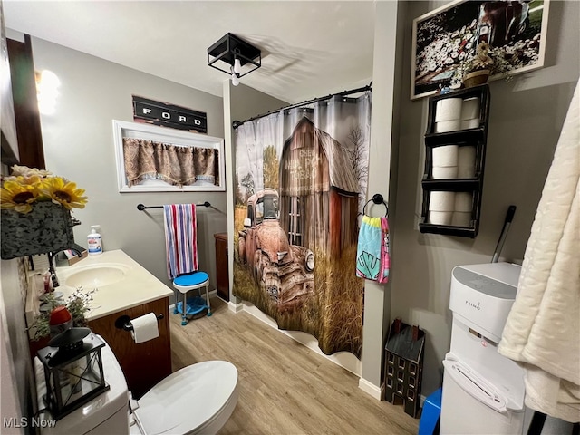 bathroom featuring wood-type flooring, vanity, and toilet