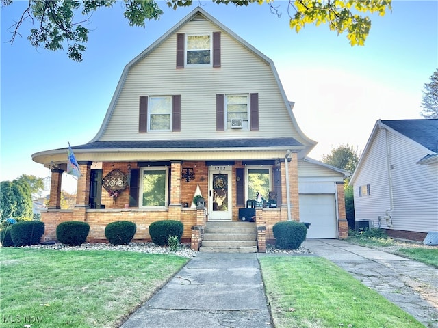 view of front of home featuring a garage, a front lawn, and a porch