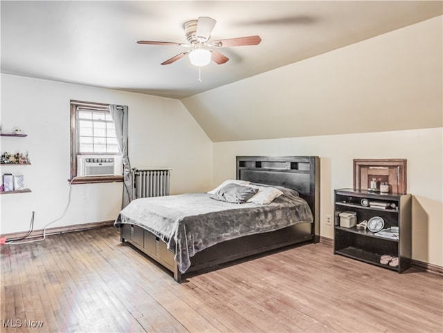 bedroom featuring light wood-type flooring, cooling unit, vaulted ceiling, and ceiling fan