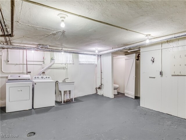 basement with separate washer and dryer and sink