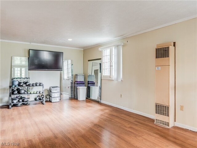 living room with light hardwood / wood-style flooring, a wealth of natural light, and crown molding