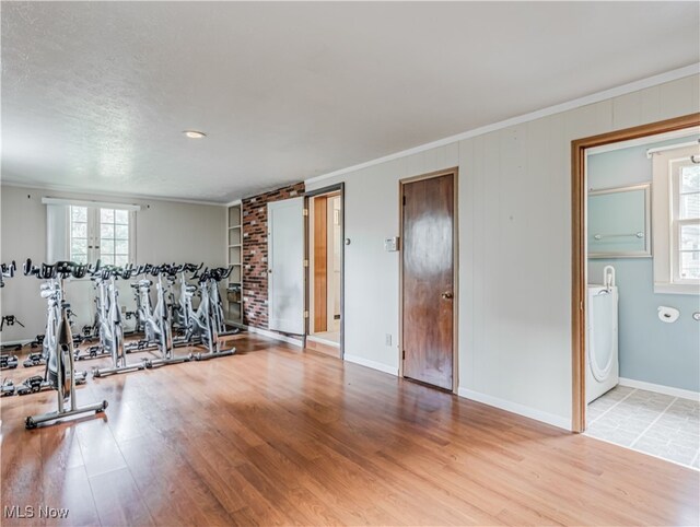 interior space with ornamental molding, wood-type flooring, washer / clothes dryer, and a textured ceiling