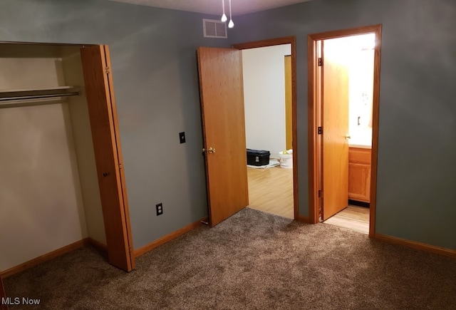 unfurnished bedroom with light colored carpet and a closet